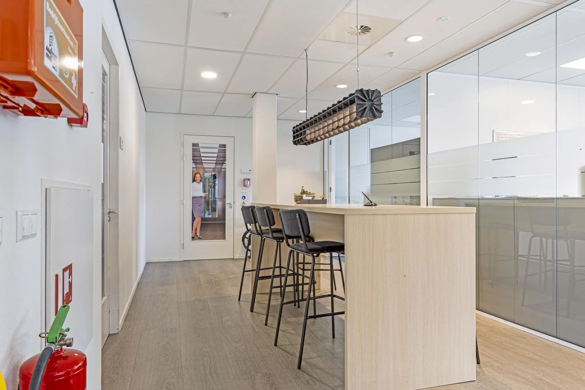 Moderne kantoorruimte aan de Fascinatio Boulevard met een hoge tafel, barkrukken en glazen vergaderruimtes.